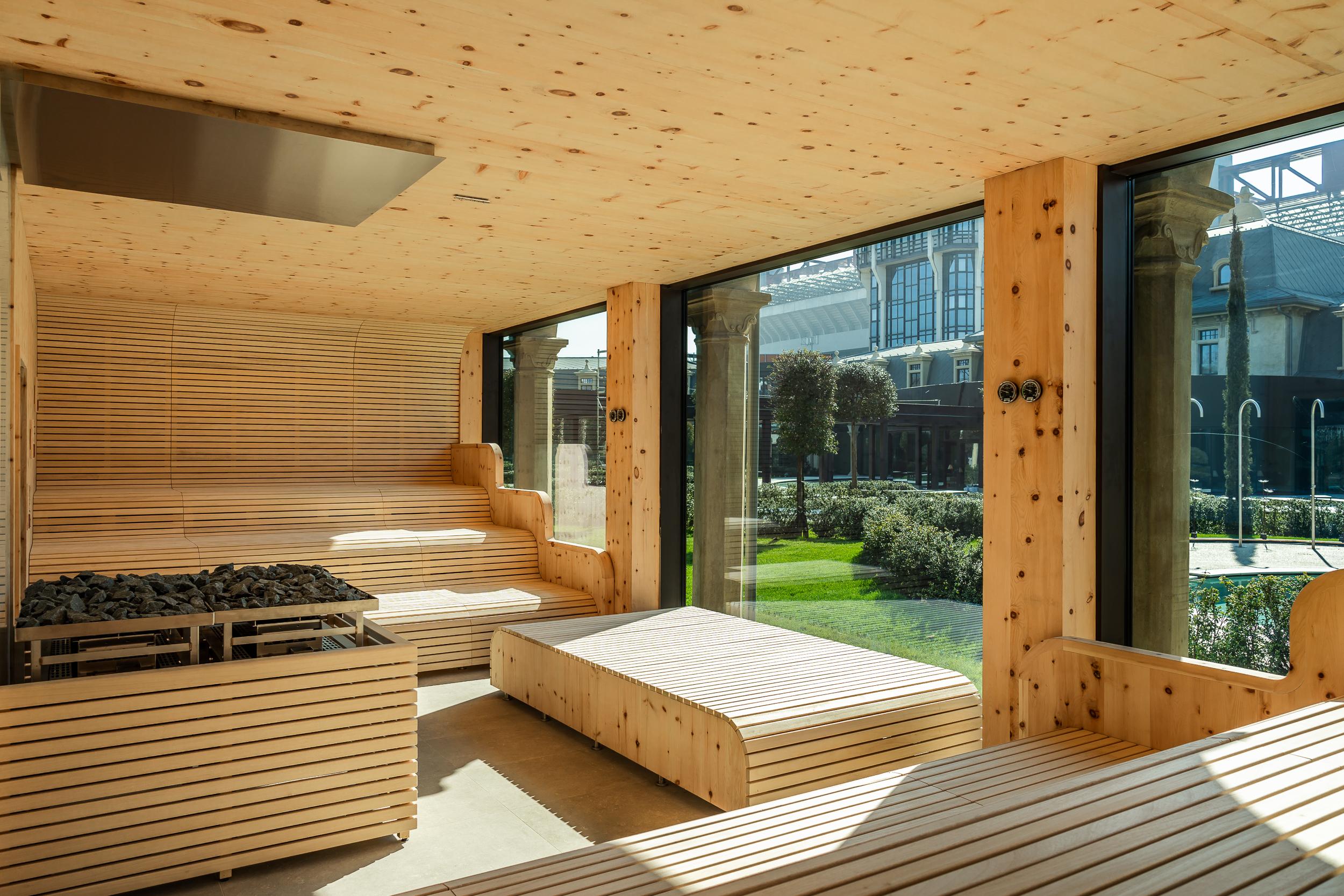 Moderna sauna in legno con ampie vetrate che si affacciano sul giardino