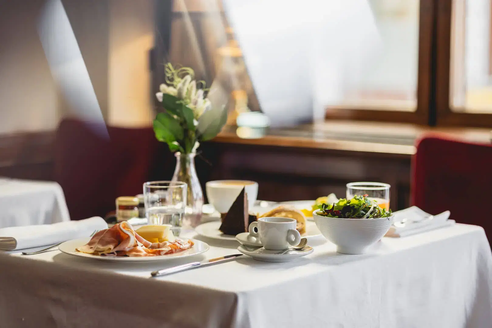 Tavolo imbandito con colazione e fiori freschi
