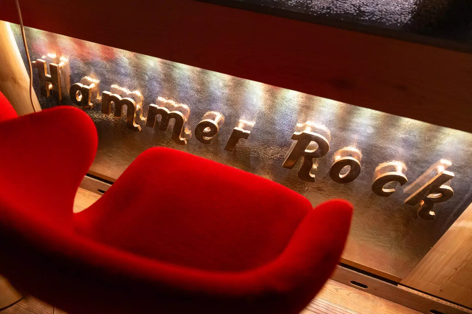 Insegna Hammer Rock con poltrona rossa