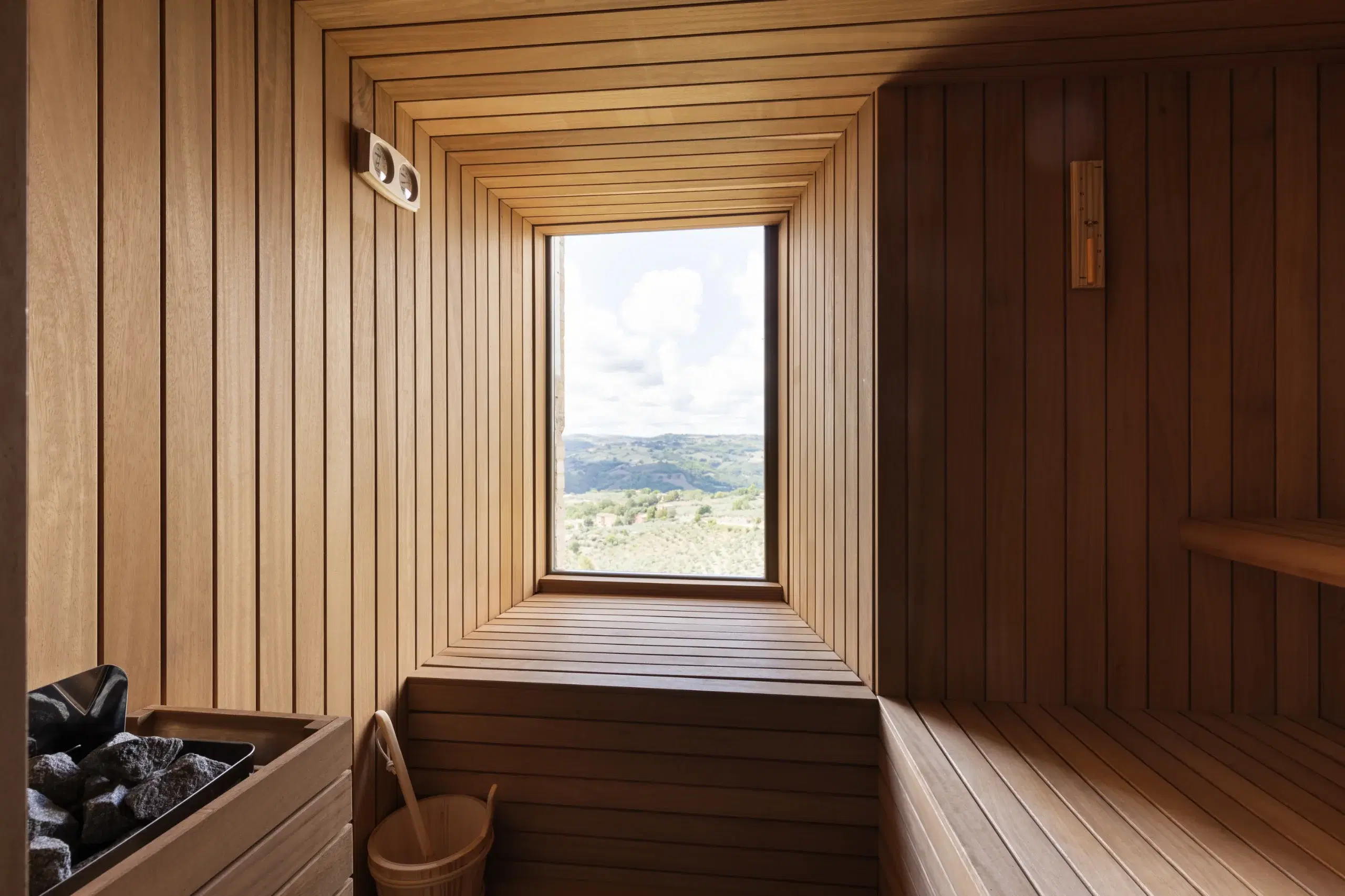 Sauna finlandese panoramica con vetrata sulle colline