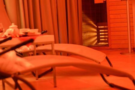 Lettini e sauna in un ambiente rilassante con luce soffusa