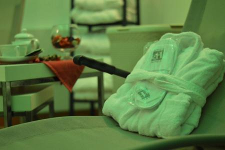 Accappatoio e ciabatte su una sedia, ambiente rilassante con tazze e decorazioni