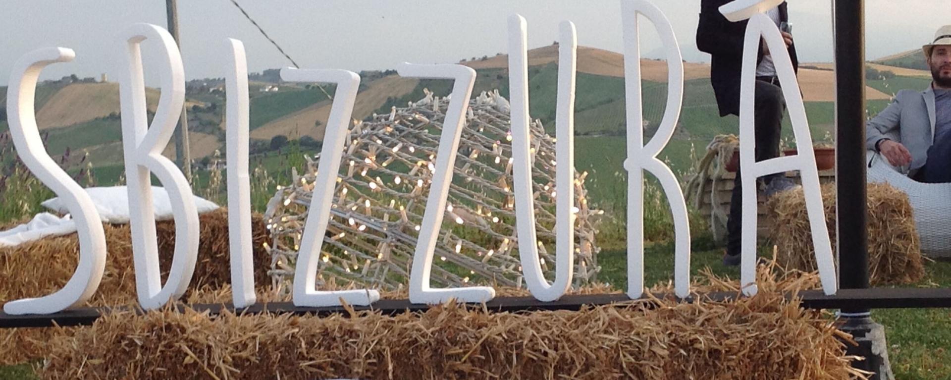 Lettere bianche su balle di fieno con paesaggio collinare
