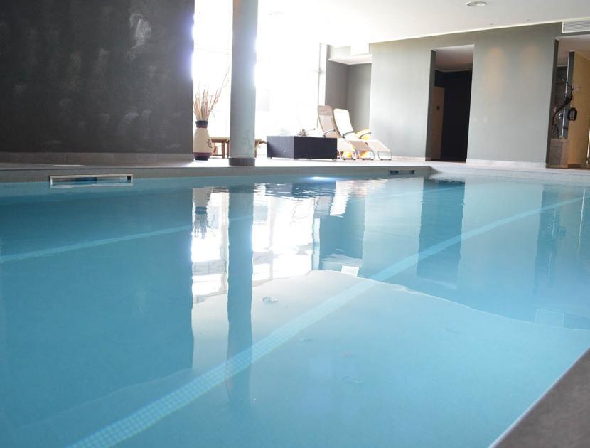 Piscina interna luminosa con sedie rilassanti