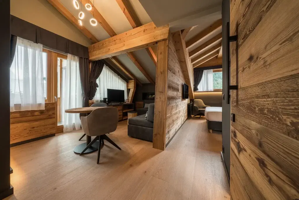 Moderna suite d'albergo in stile alpino con arredi in legno e ampie finestre