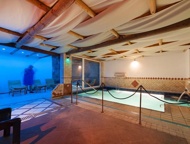 Piscina interna con sedie a sdraio e illuminazione soffusa