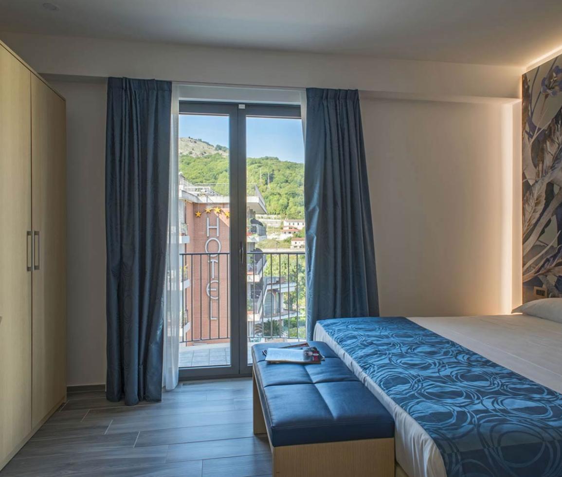 Camera moderna e luminosa con vista montagna, atmosfera rilassante e accogliente