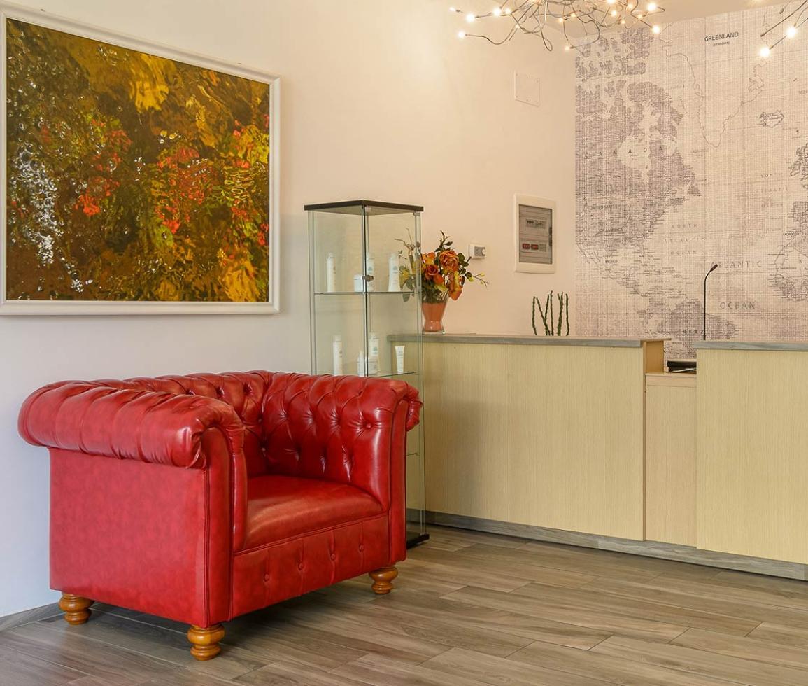 Accogliente reception con divano rosso, mappa mondiale e luci calde