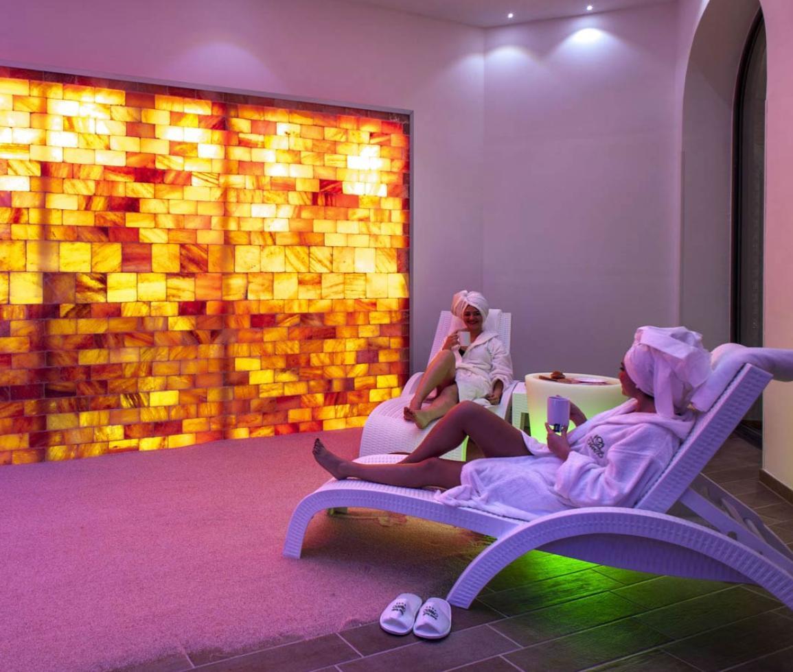 Due persone rilassate in spa, luce calda e atmosfera serena