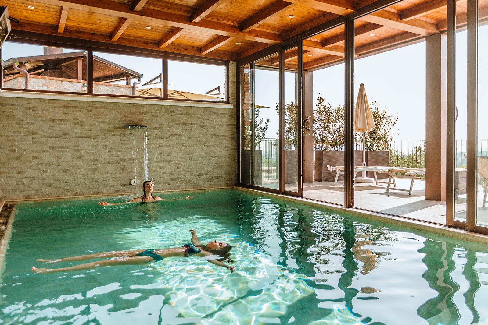 Piscina a sfioro con cascata e terrazza solarium panoramica