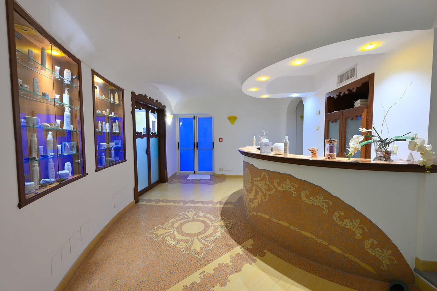 Cabina trattamenti con arredamento in legno e maioliche gialle