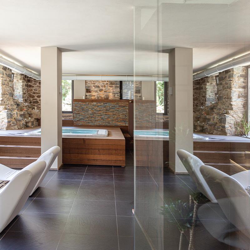 Area spa con pareti in pietra ligure, sauna e luci calde