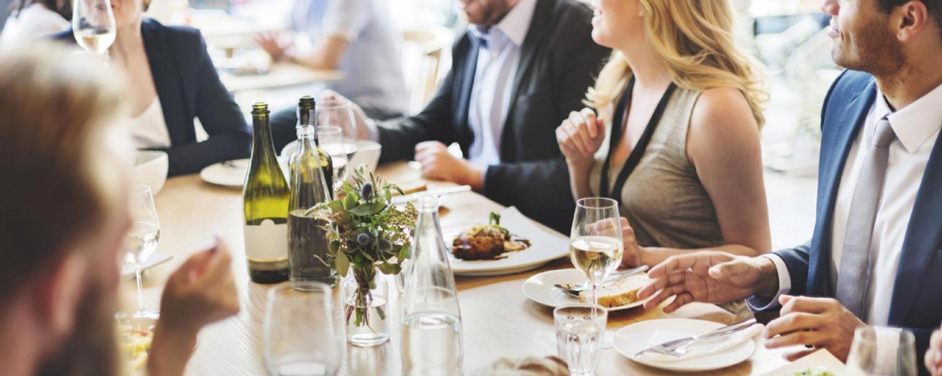Gruppo elegante a tavola in atmosfera conviviale