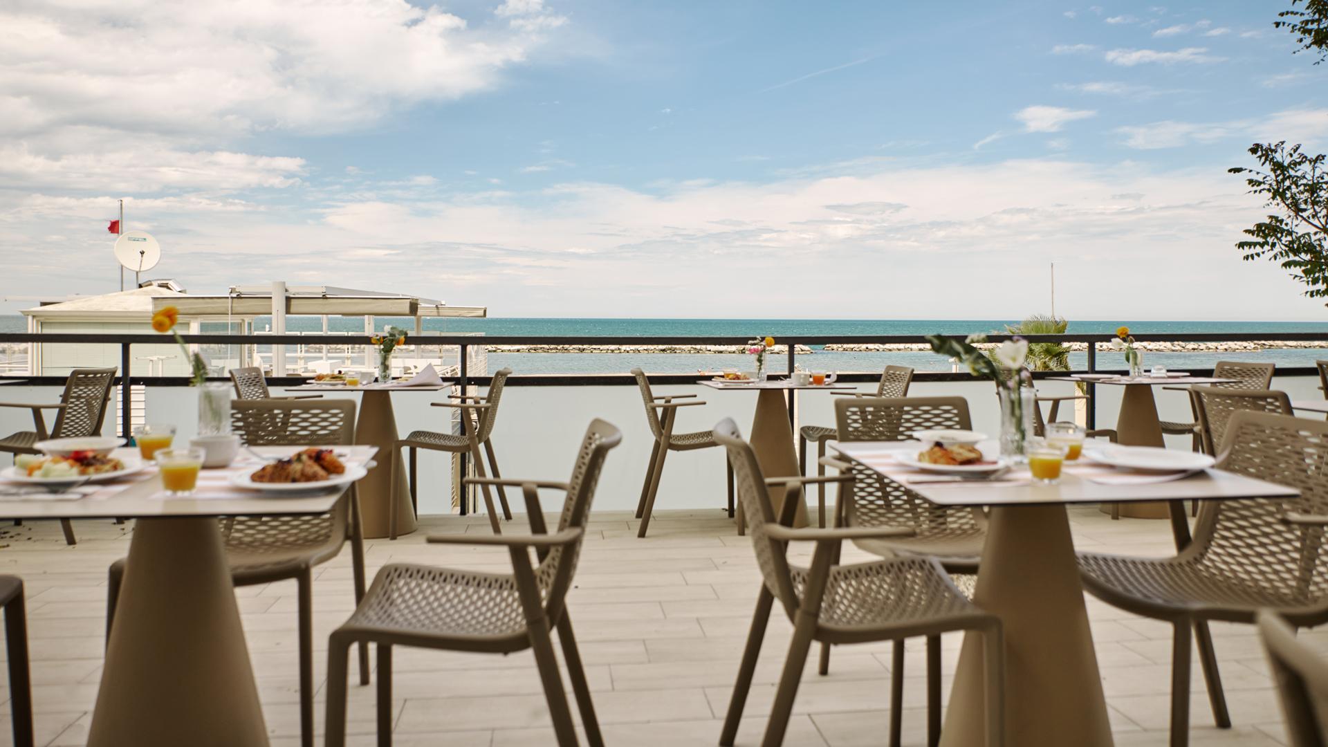 Terrazza con vista mare e tavoli apparecchiati