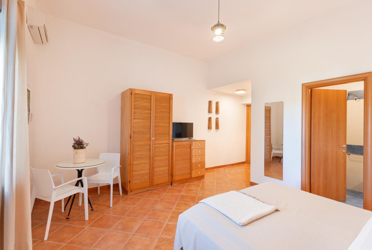 Camera luminosa con arredi in legno e pavimento in terracotta