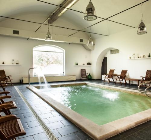 Piscina interna elegante con sedie a sdraio in legno e illuminazione moderna