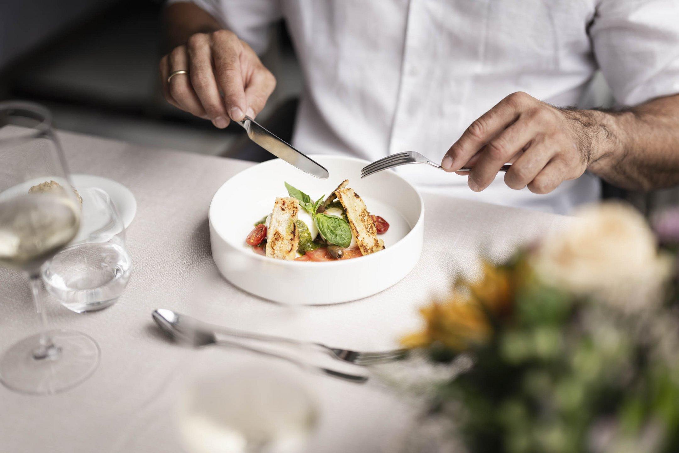 Piatto gourmet con pomodori e basilico su ciotola bianca