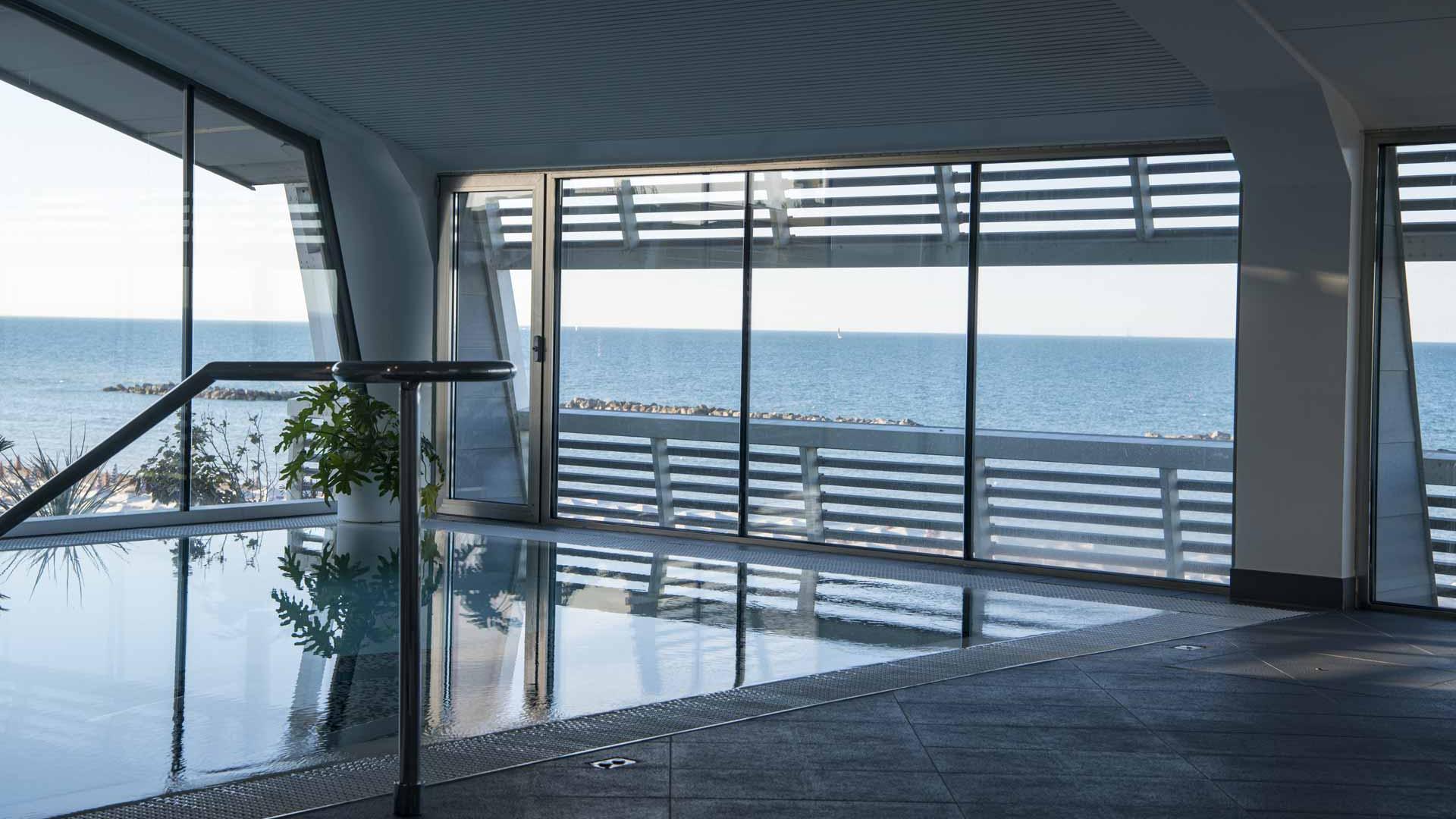 Piscina interna con vista mare, atmosfera rilassante e moderna
