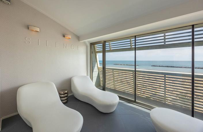 Vista mare rilassante con lettini bianchi e atmosfera silenziosa