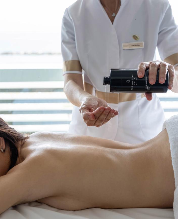 Massaggio rilassante con olio profumato, mani esperte e atmosfera serena